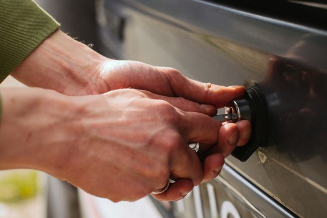 a pair of hands attempting to unlock a car with a key