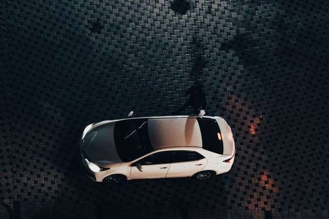 white car driving on an empty path